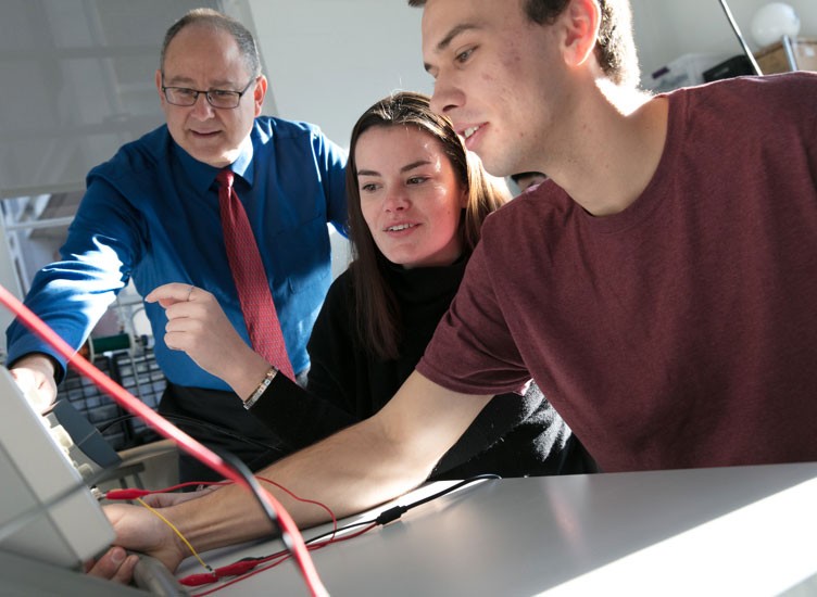 Professor works with students on engineering project